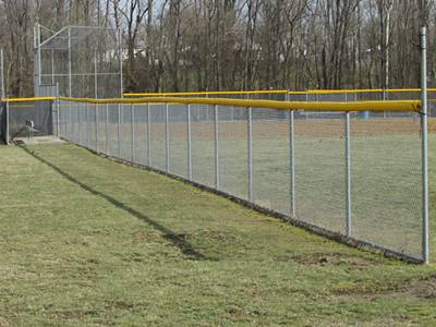 Chain link baseball field fence and backstop fence with yellow fence topper.